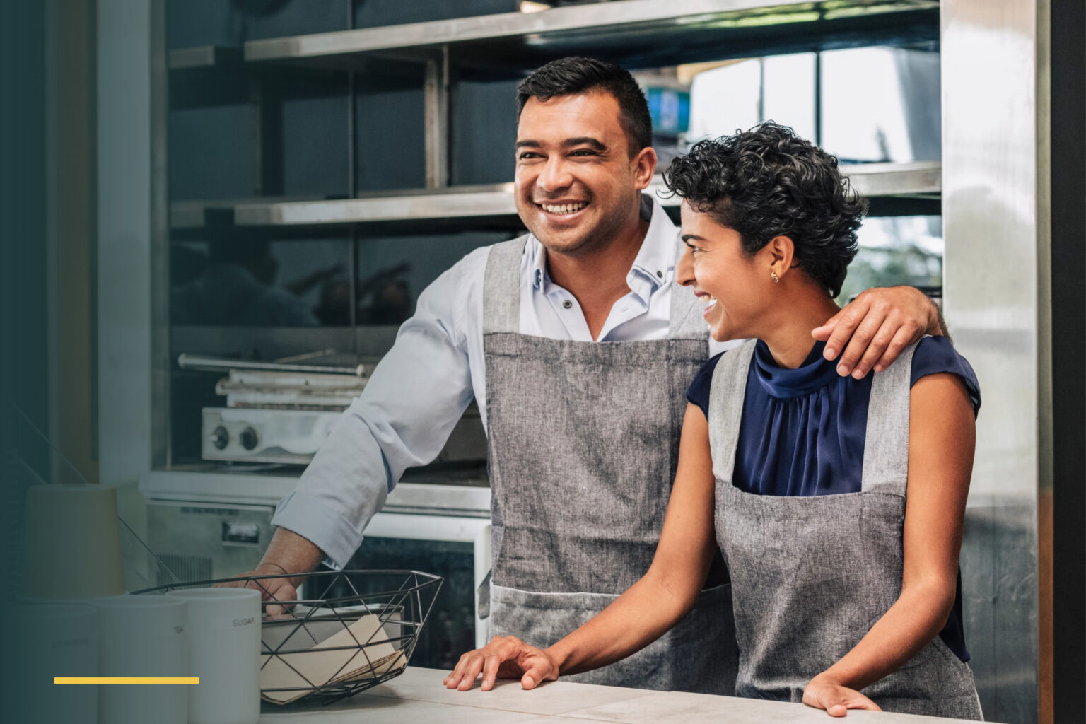 Smiling small business owners behind the counter of their cafe